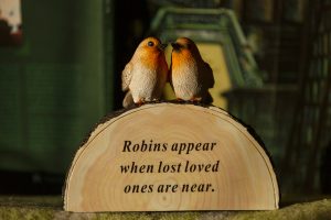 Figurka z dwoma rudzikami i sentencją: "Robins appear when lost loved ones are near".